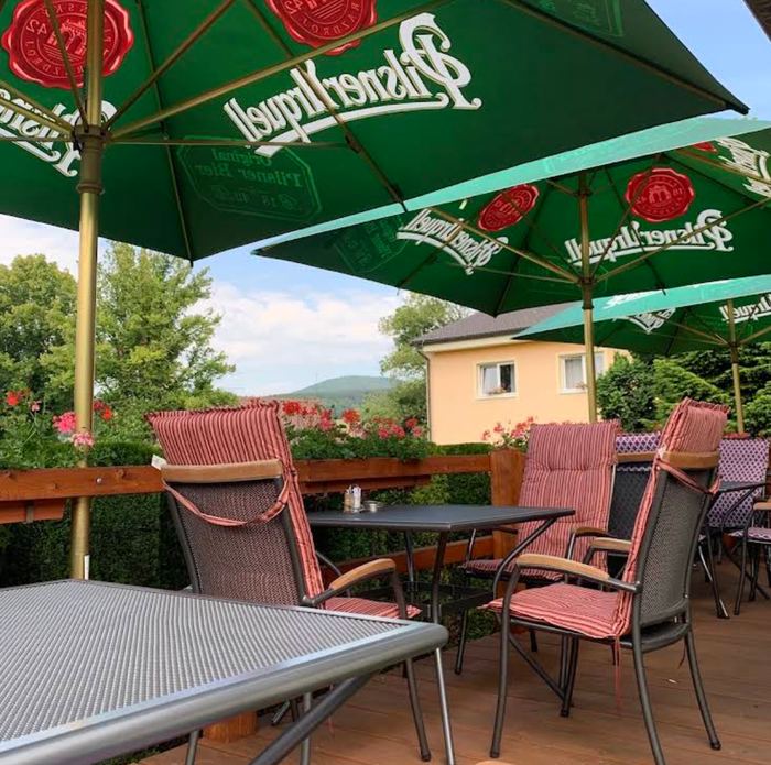 Terrasse mit Sonnenschirmen und Blick auf die Hügel