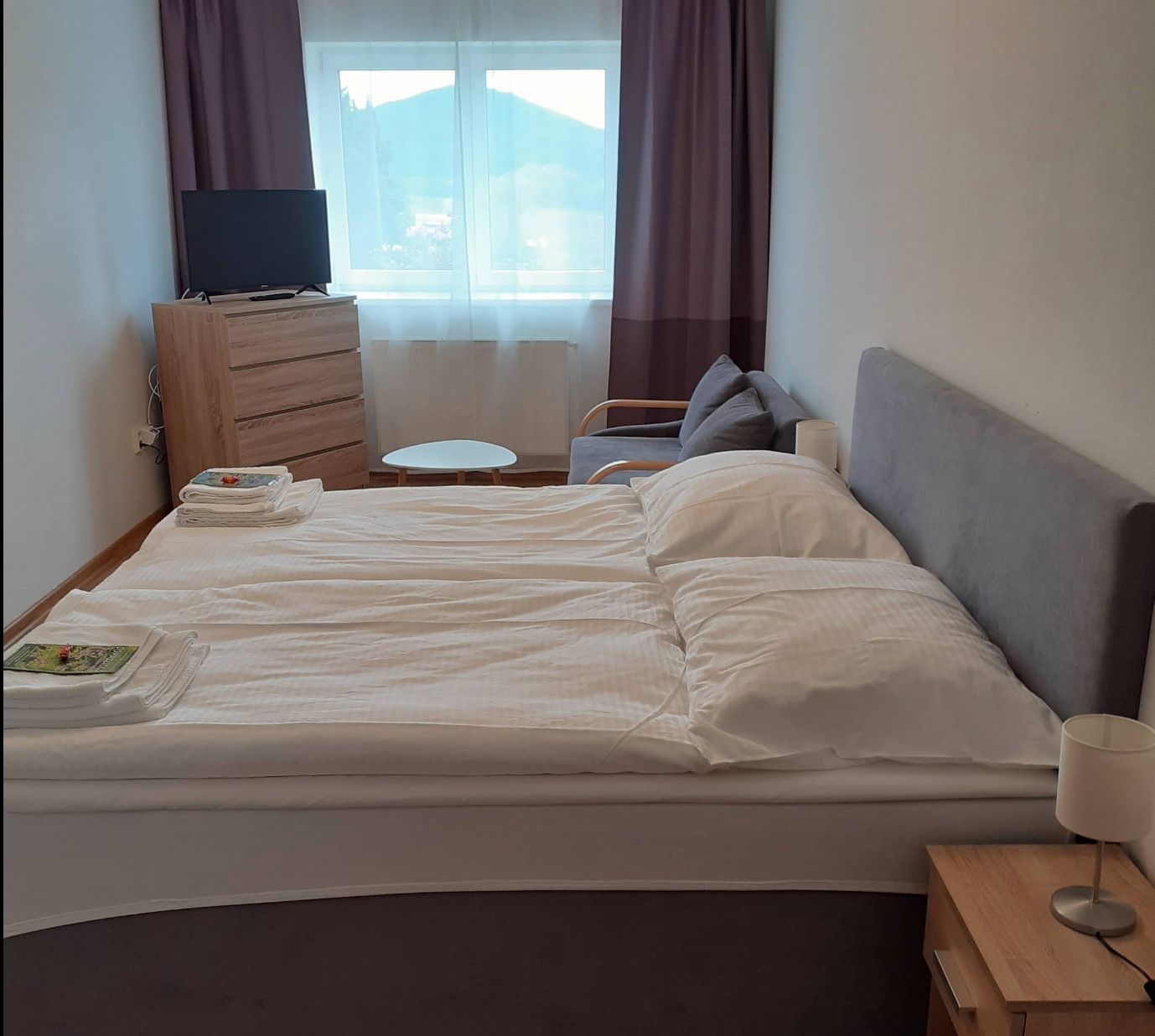 Pensionszimmer mit Doppelbett und Blick aus dem Fenster